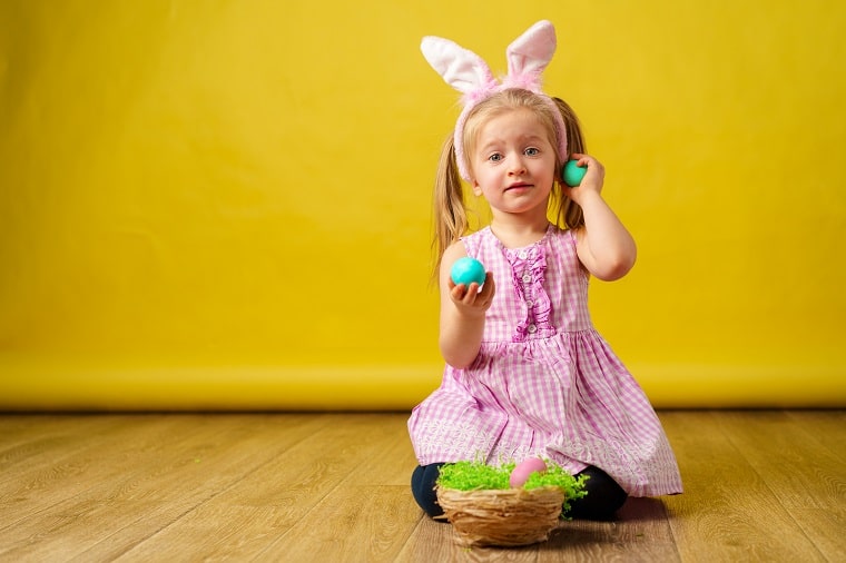 toddler games - blonder happy girl with bunny ears and easter egg basket