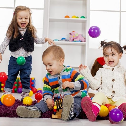 play based learning - toddlers happily playing with plastic balls