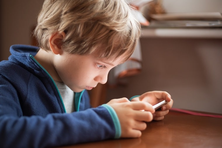 outdoor play - boy using cellphone