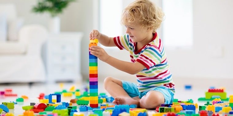 Fine motor skills activities for toddlers - little boy playing with blocks
