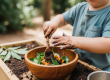 A toddler engaged in sensory messy play with a mud kitchen at Okinja Early Learning Centre on the Sunshine Coast.